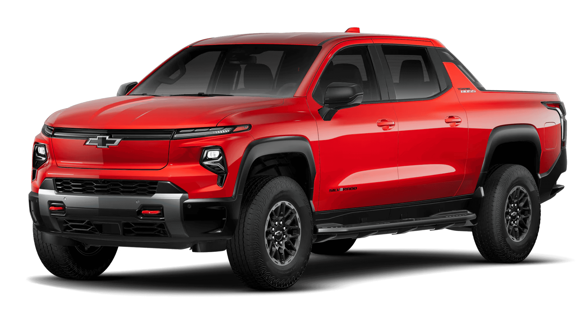 Studio image of a red 2026 Chevy Silverado EV Trail Boss in three quarter front view on black background