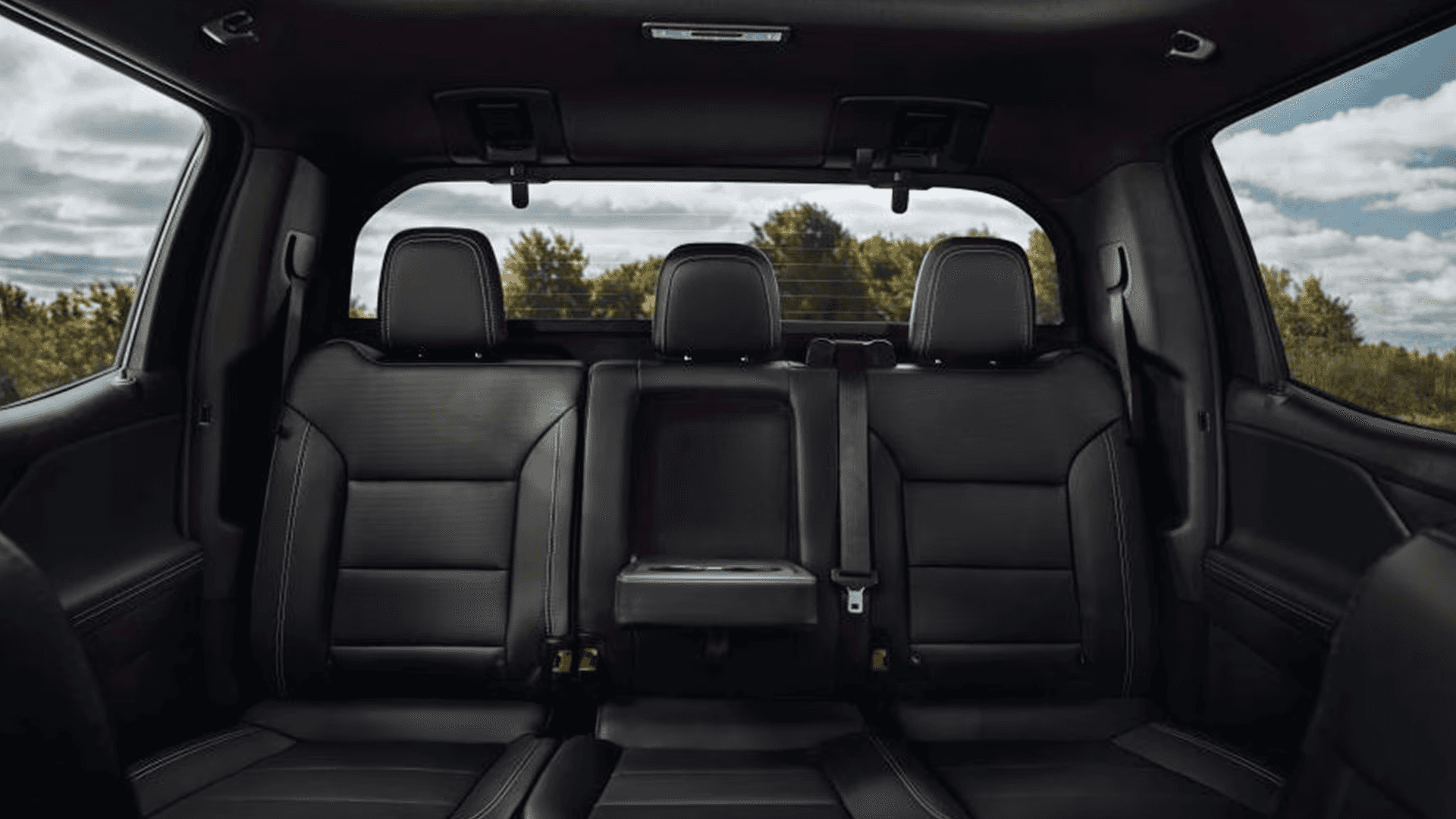 Rear seat bench in Silverado EV with fold-down armrest, three headrests, and wide cabin windows
