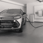 Silver Chevy Equinox EV RS plugged in at home garage with wall-mounted charger and energy equipment
