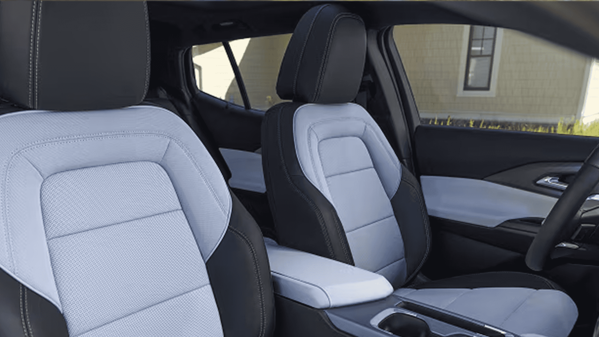 Front cabin of 2026 Chevy Equinox EV with two tone seats, center console, and door trim details