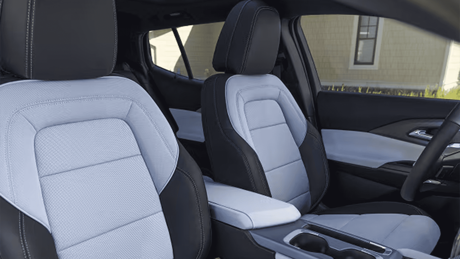 Two-tone front seats and center console in 2026 Equinox EV cabin with contrast stitching and cupholders