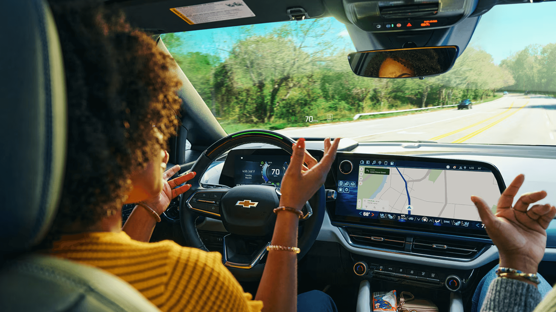 Driver using Super Cruise in a Chevy Equinox EV with hands free driving active and navigation displayed on center screen
