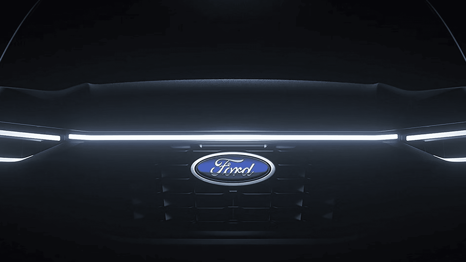 Close-up of 2026 Ford Escape front with illuminated LED light bar and Ford badge centered on grille.