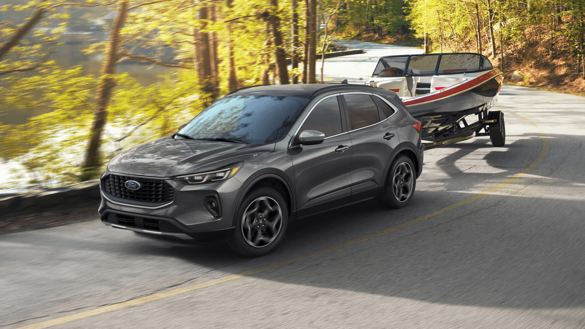 Gray 2026 Ford Escape towing a boat on a curving wooded road, showing towing capability and stability.