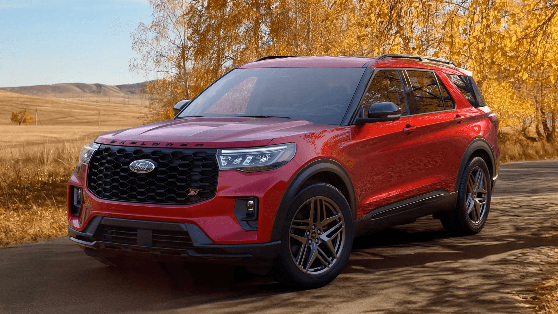 Red 2026 Ford Explorer ST parked on rocky terrain, emphasizing ground clearance and SUV presence.