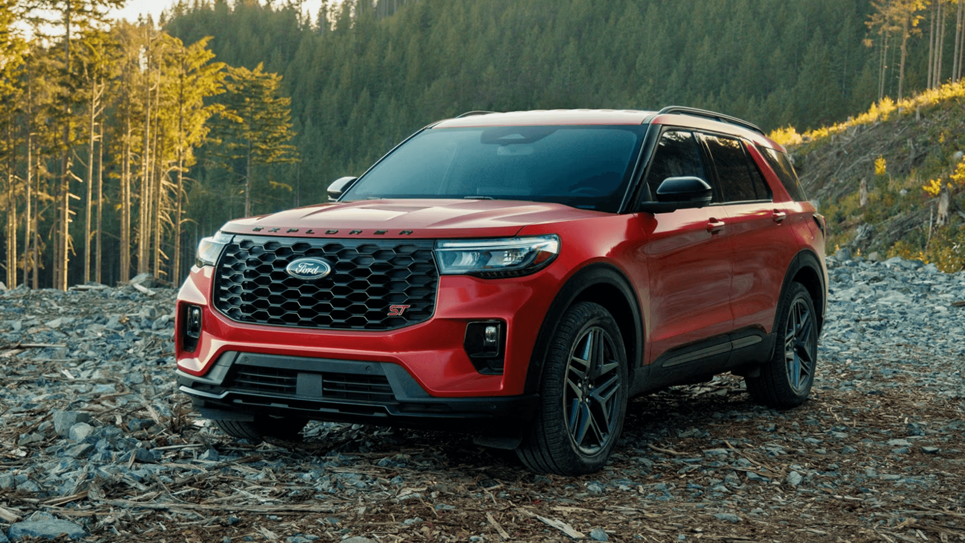 Front view of 2026 Ford Explorer Tremor on dirt trail with distinctive grille and tow hook accents.