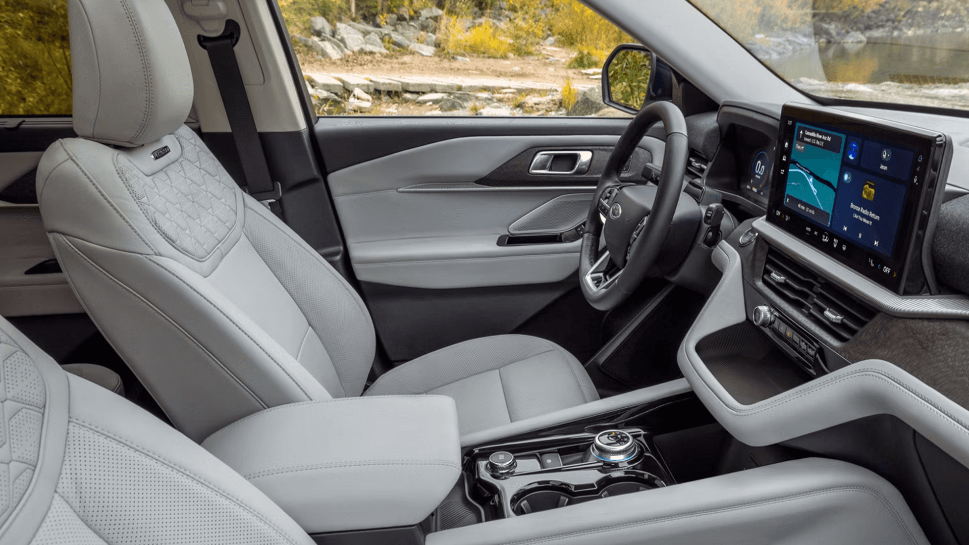 2026 Ford Explorer front cabin with light gray seats, rotary dial shifter, and wide center touchscreen