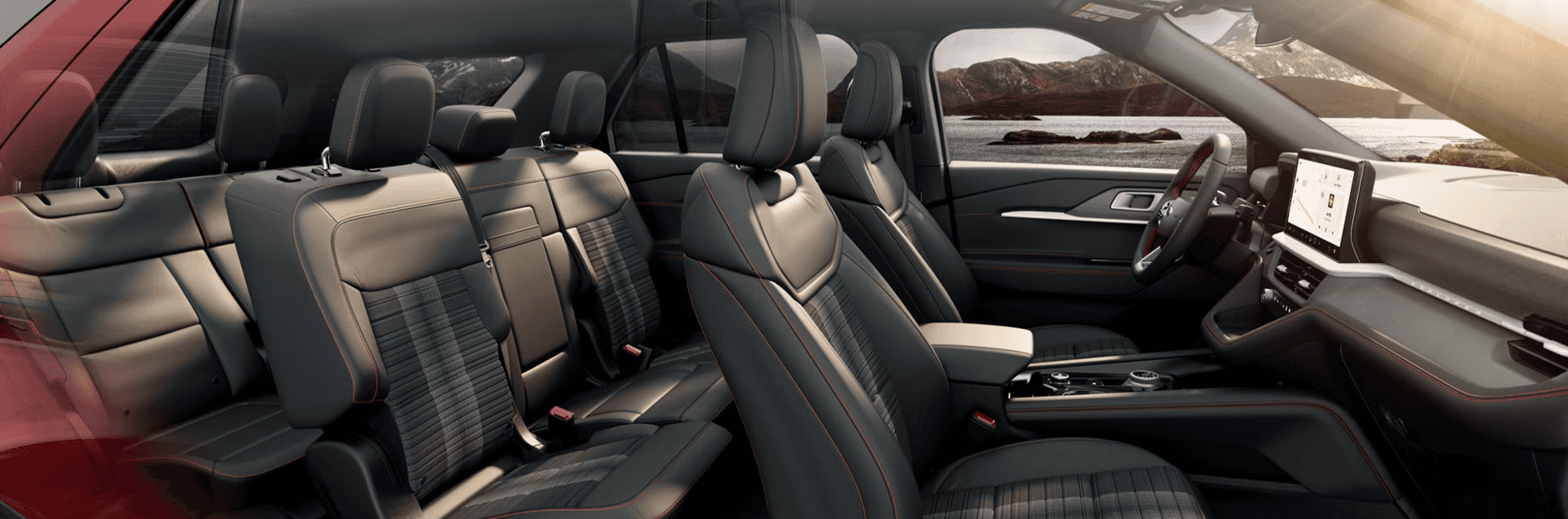 2026 Ford Explorer interior with three rows, black seats with red stitching, and large center touchscreen