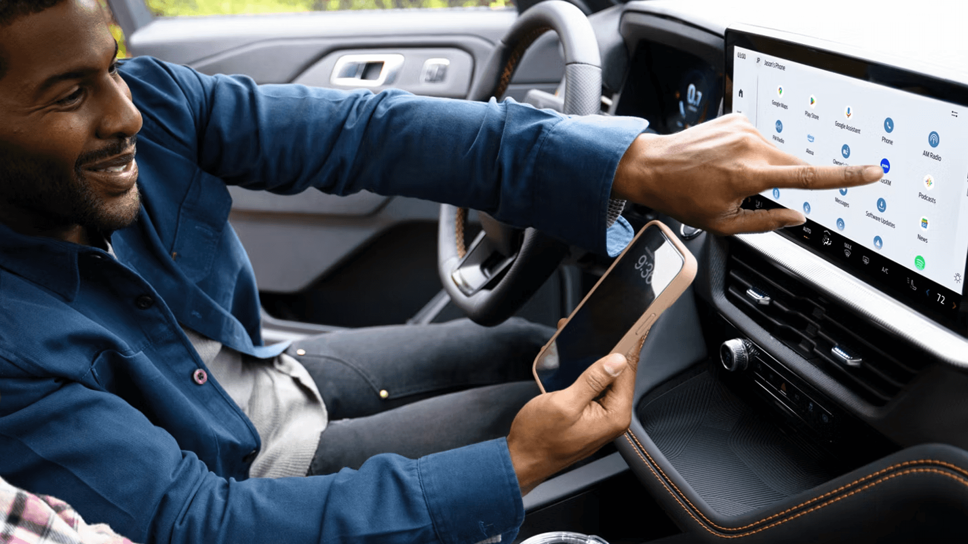 Driver holding smartphone while selecting apps on 2026 Ford Explorer touchscreen display