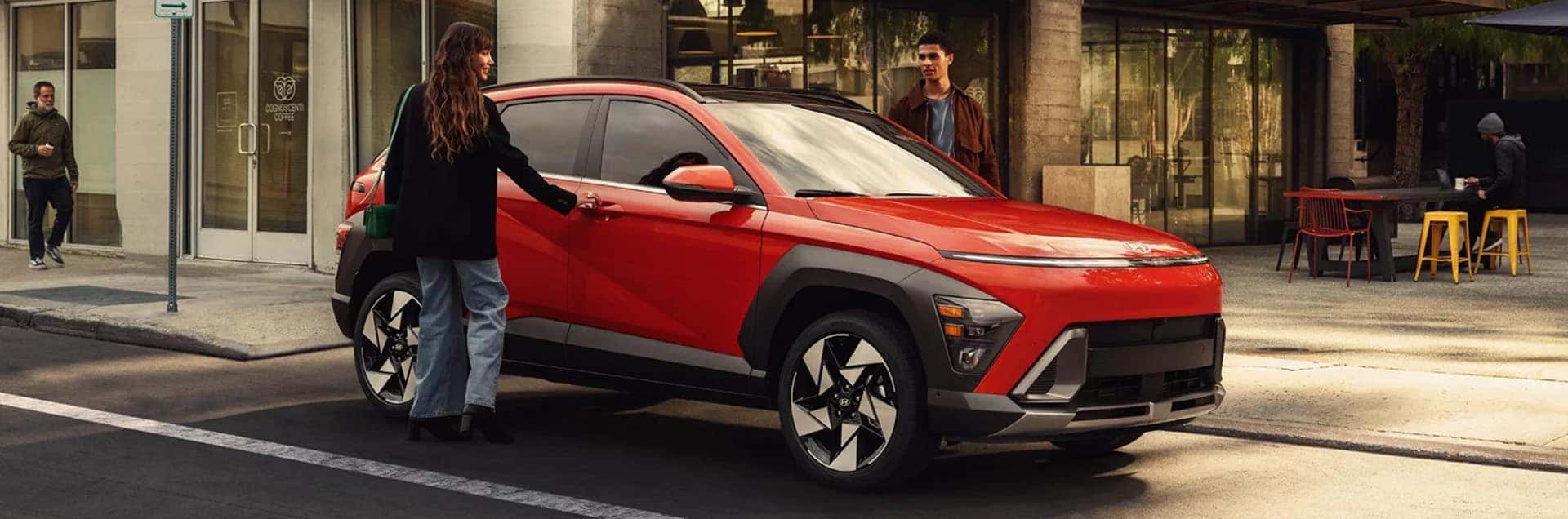 2026 Hyundai Kona Hybrid parked on a city street with pedestrians nearby, showcasing its modern exterior design and compact SUV styling