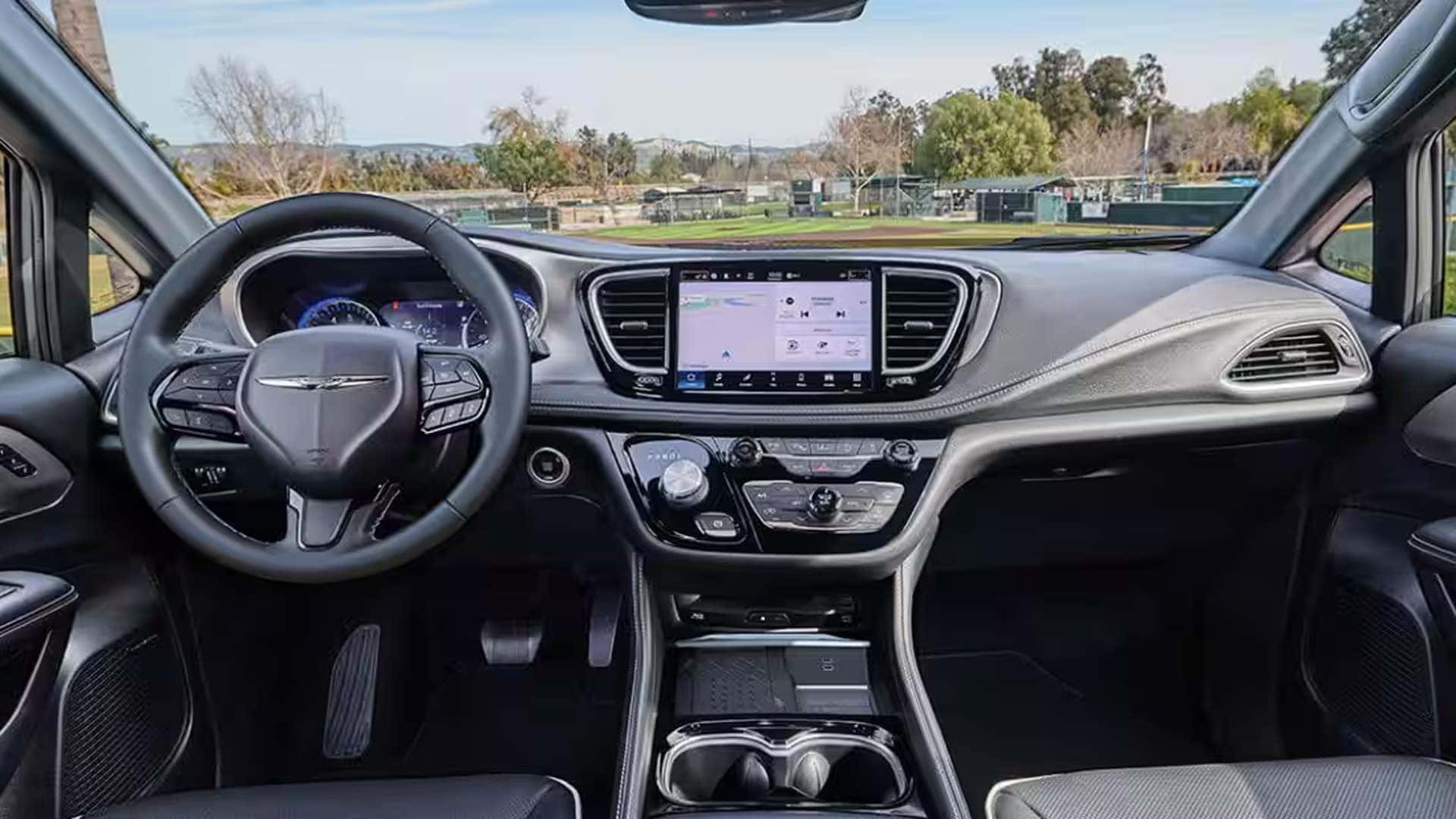2026 Chrysler Pacifica cockpit with steering wheel, digital gauges, and center touchscreen on the dashboard
