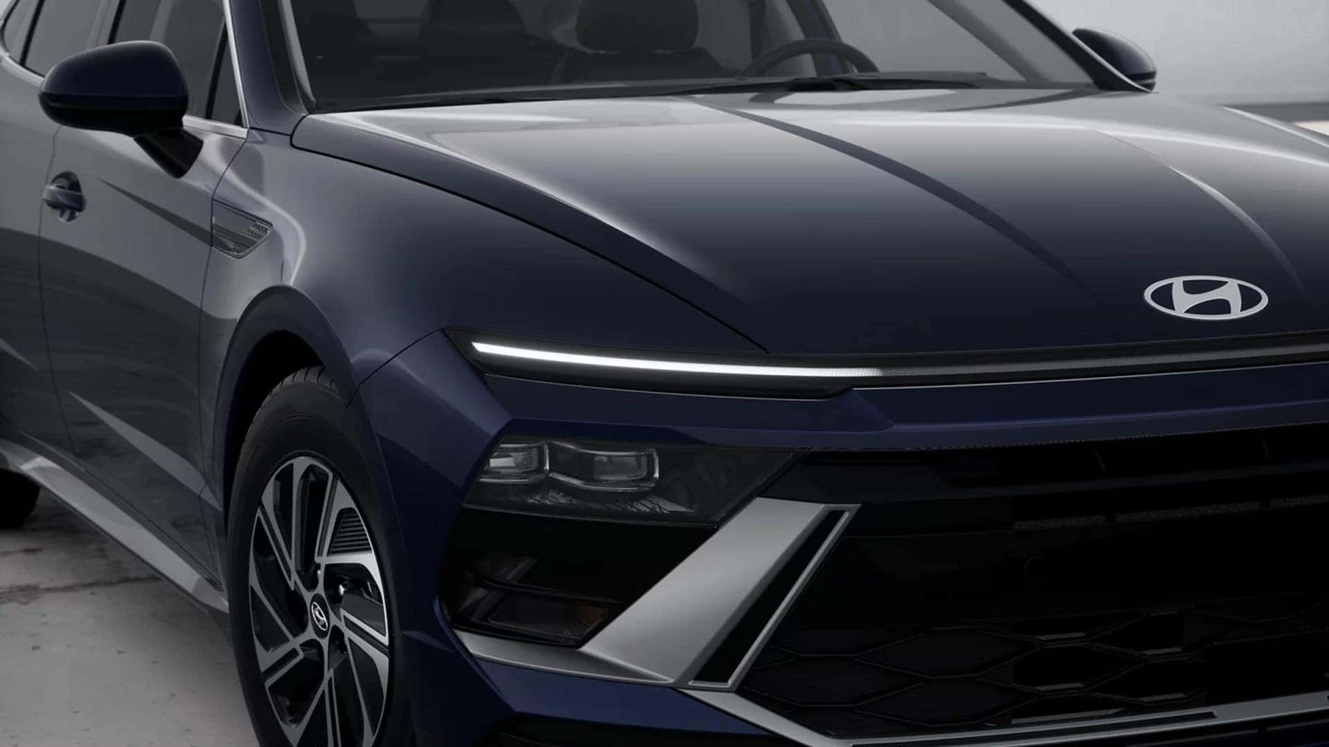 Close up of the 2026 Hyundai Sonata Hybrid front fascia with LED light strip, sculpted hood lines, and modern grille styling.