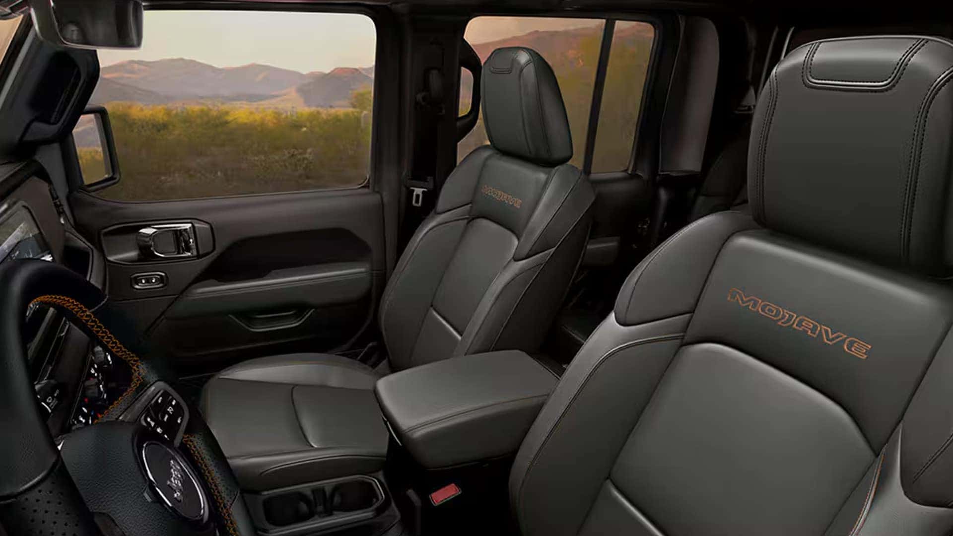 2026 Jeep Gladiator Mojave interior with front seats and center console, showing durable upholstery and spacious cabin layout