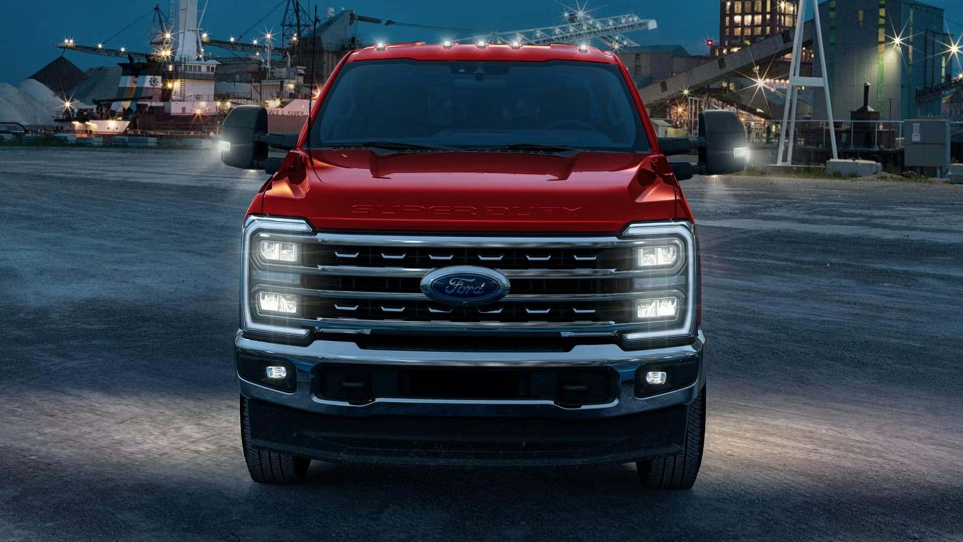 2026 Ford F-250 Super Duty at night with LED headlights and signature front lighting illuminated, showing grille detail and mirror lights.