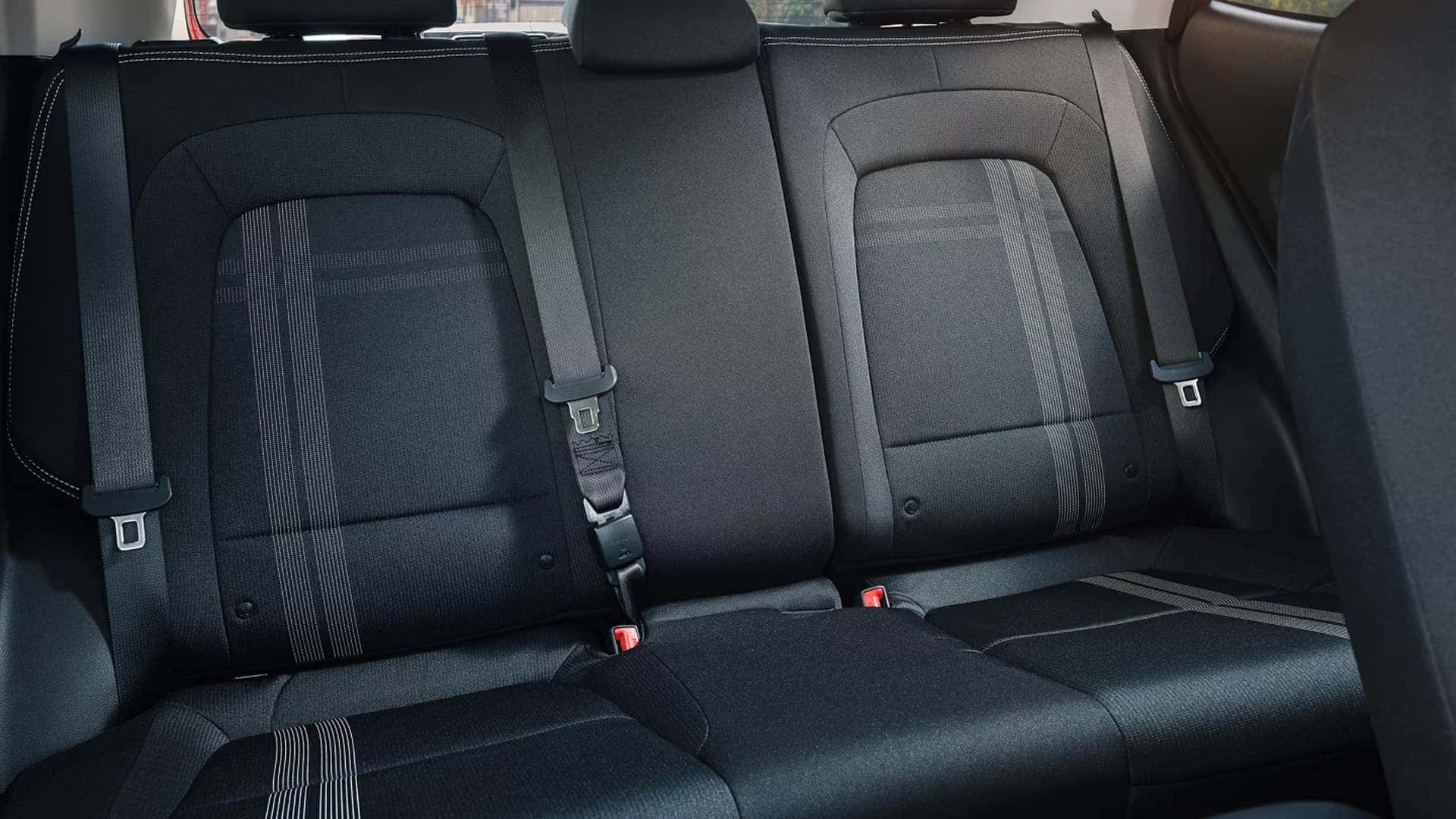Rear bench seating in the 2026 Hyundai Venue interior with three seatbelts, headrests, and patterned cloth upholstery.