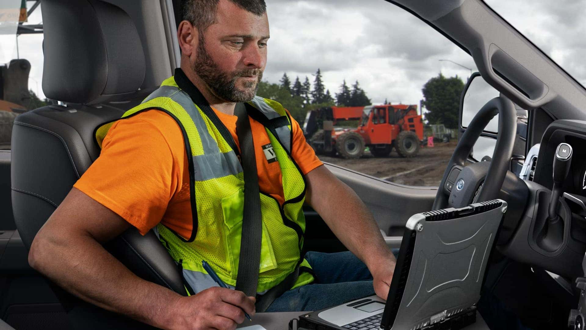 Available interior work surface inside the 2026 Ford F-250 Super Duty with a laptop set up on the fold-flat center console