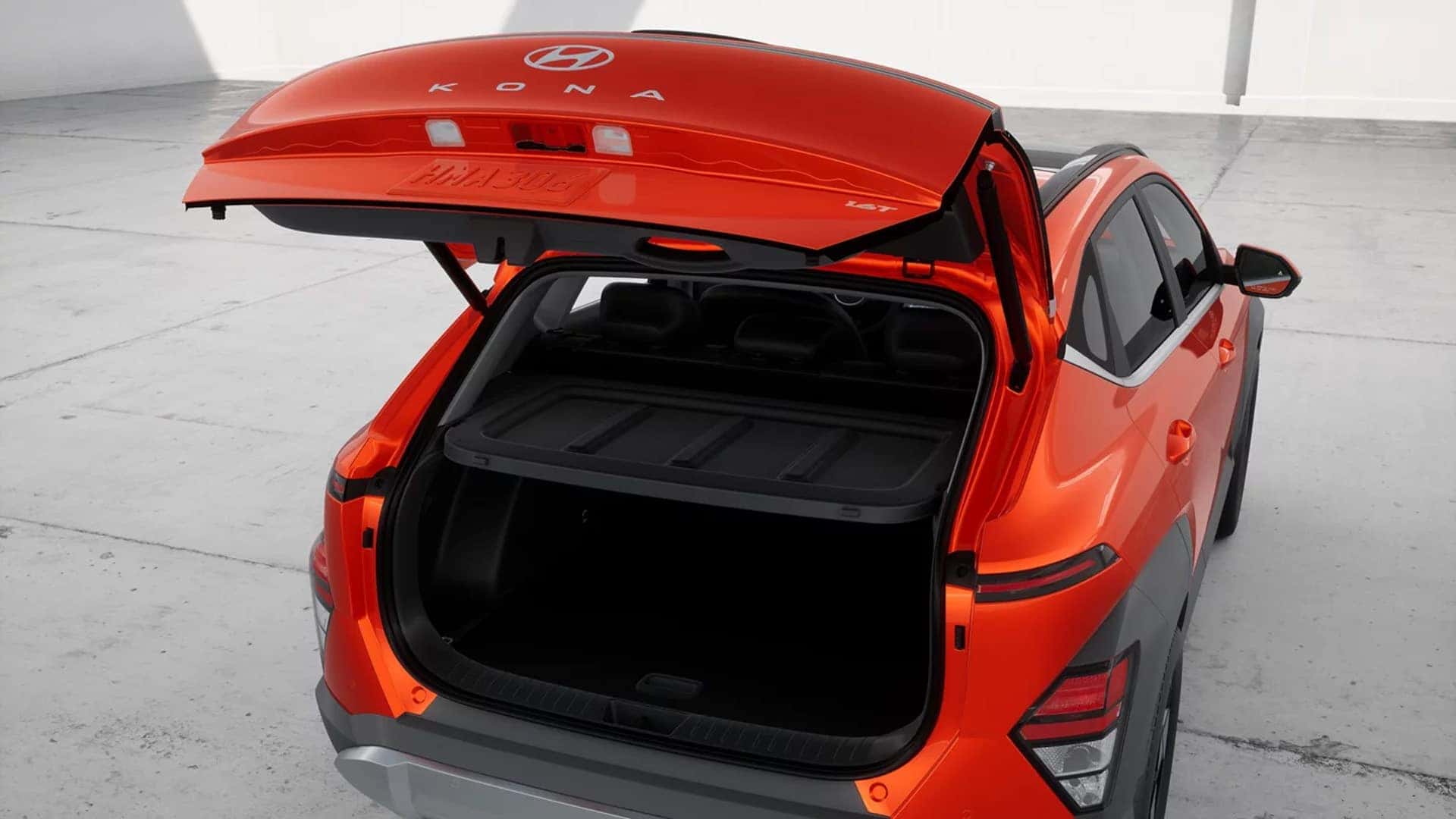 Rear view of a red 2026 Hyundai Kona with liftgate open, showing cargo area access and rear exterior styling.