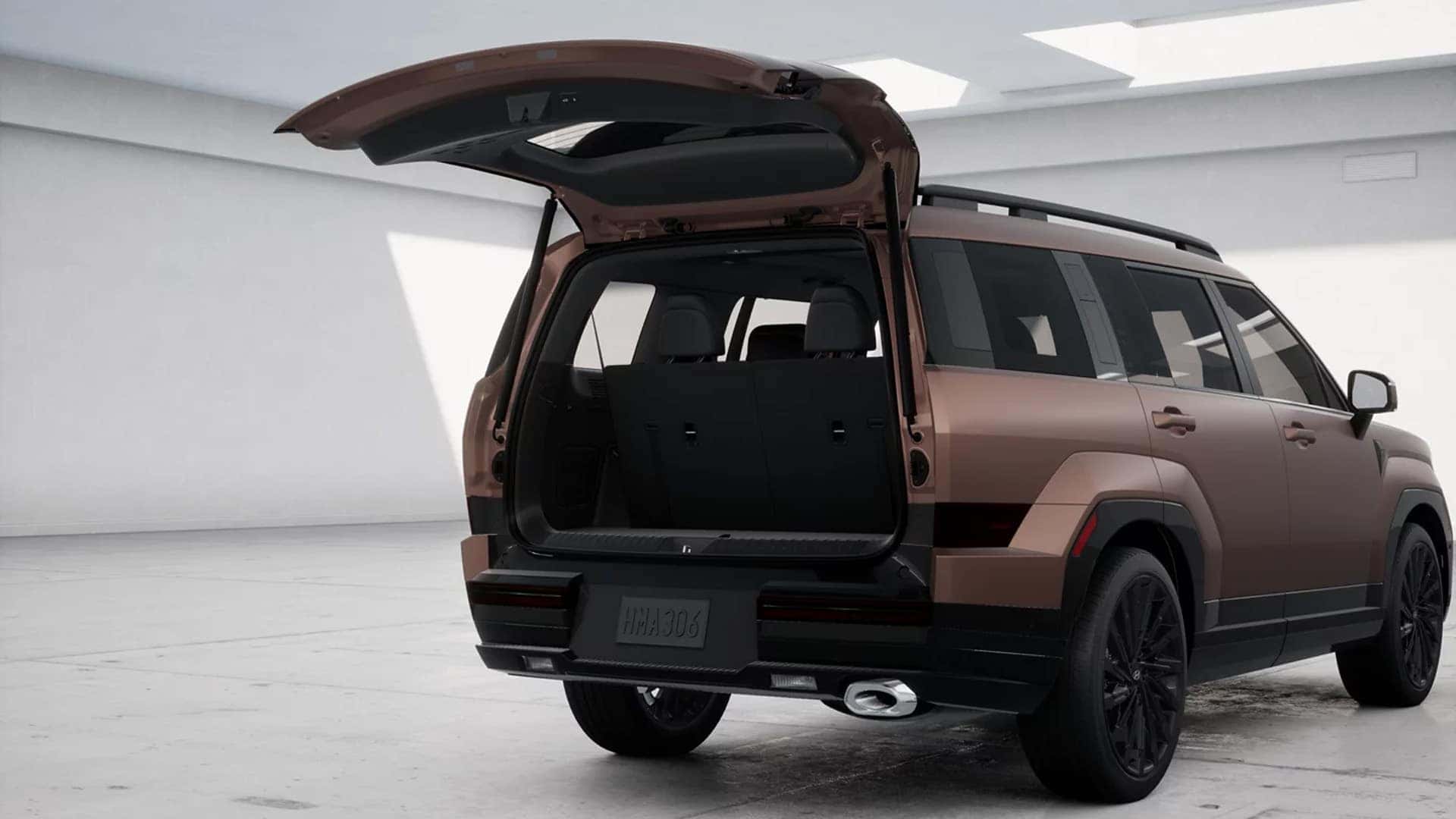 Rear view of a bronze 2026 Hyundai Santa Fe with liftgate open, showing wide cargo opening and upright tailgate design.