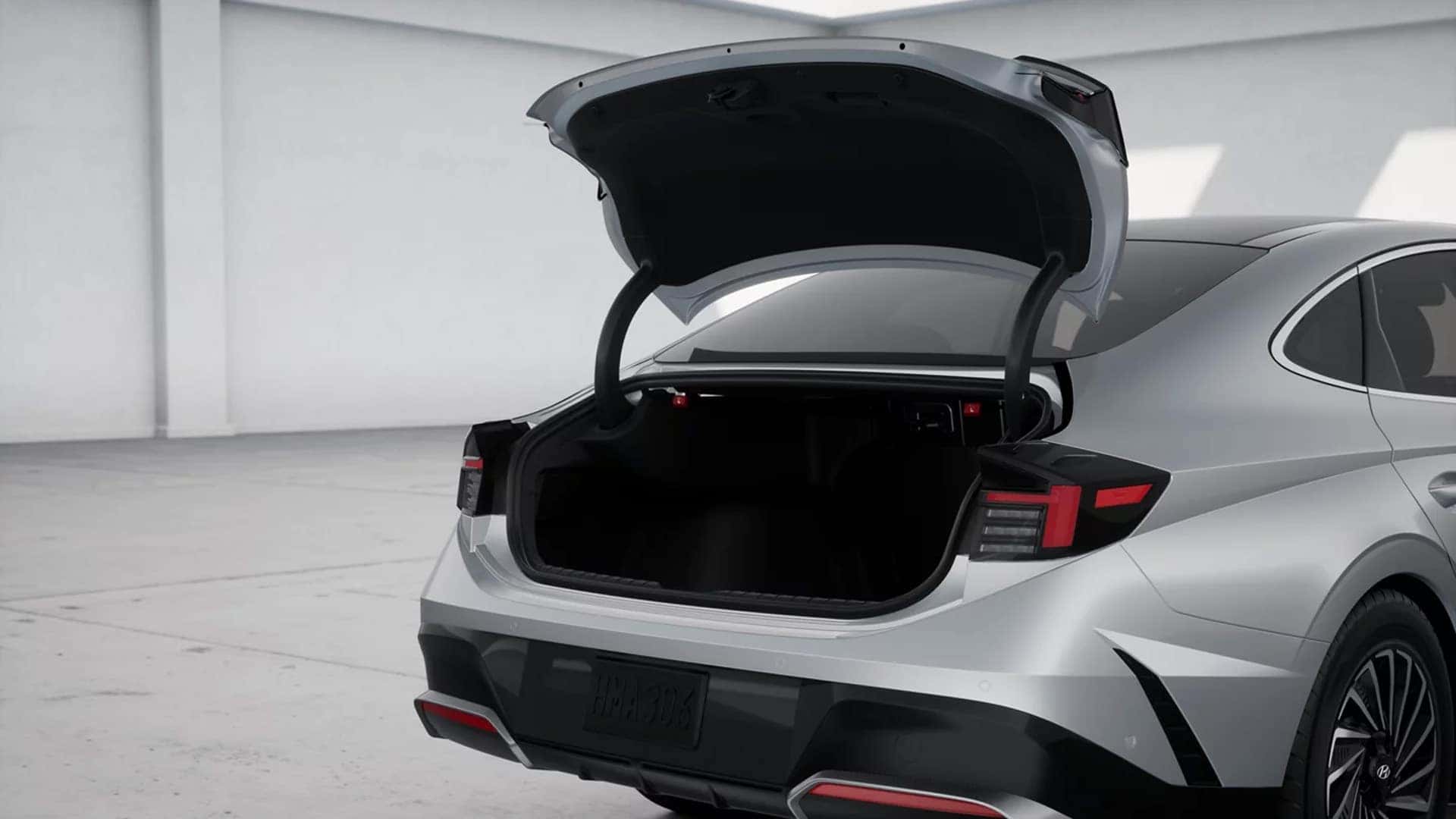 Rear view of a 2026 Hyundai Sonata Hybrid with trunk open, displaying cargo access and LED tail light design.