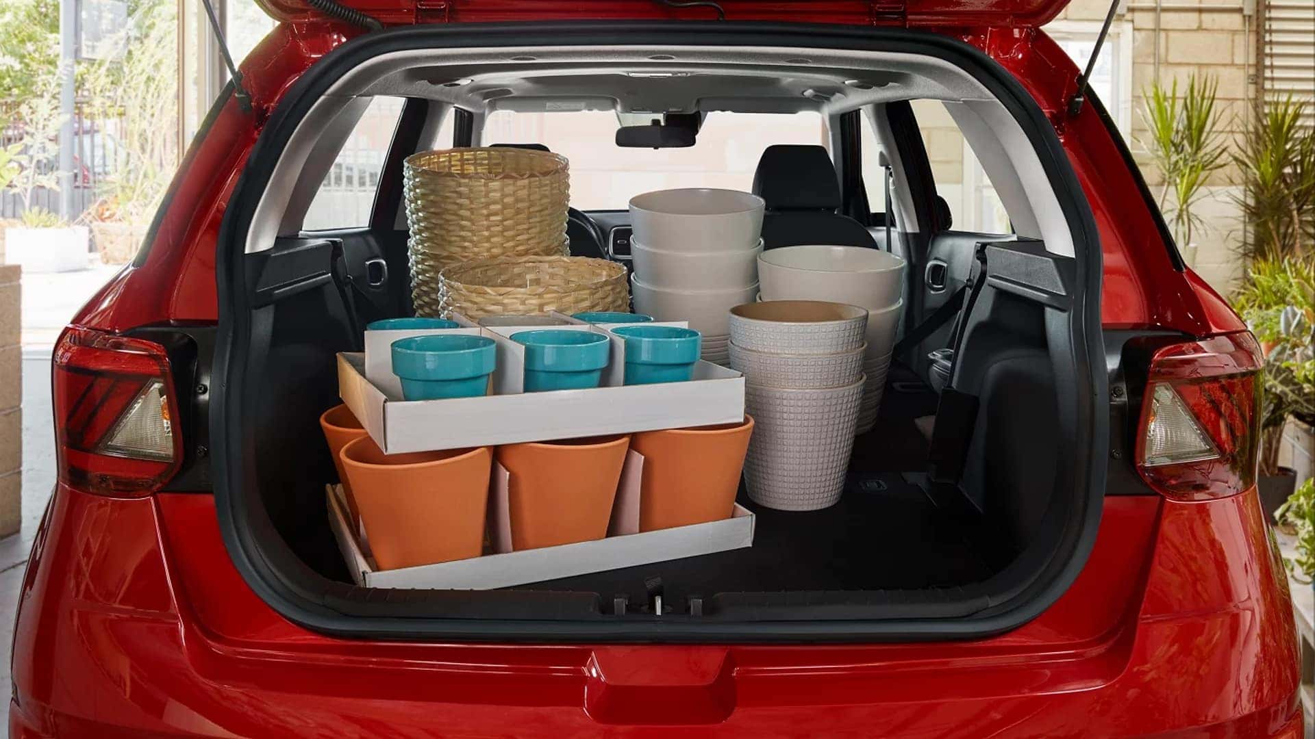 Open liftgate of 2026 Hyundai Venue displaying cargo space with storage bins and everyday items loaded inside.