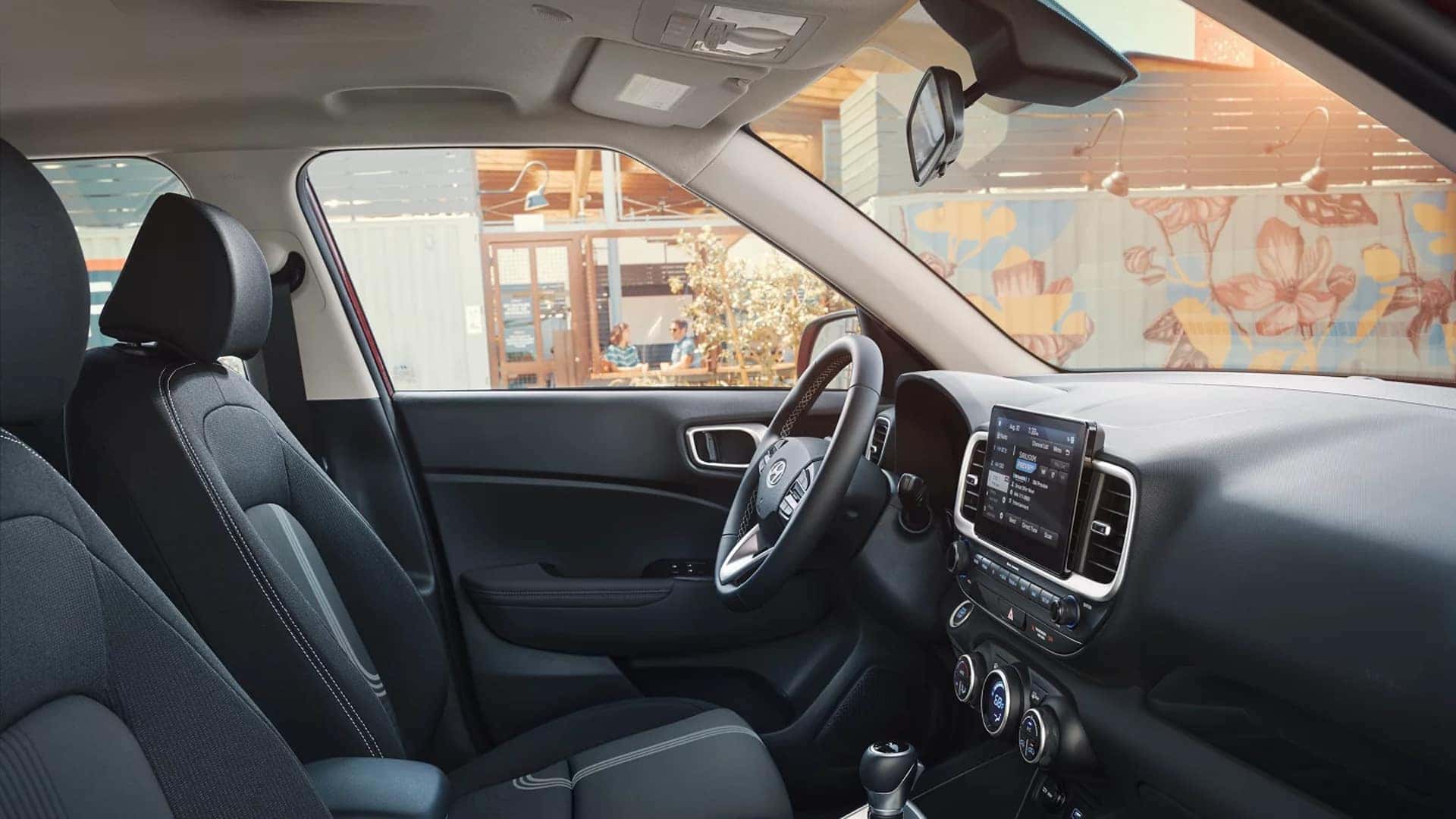Front cabin view of the 2026 Hyundai Venue showing supportive seats, center touchscreen, and easy to reach climate controls