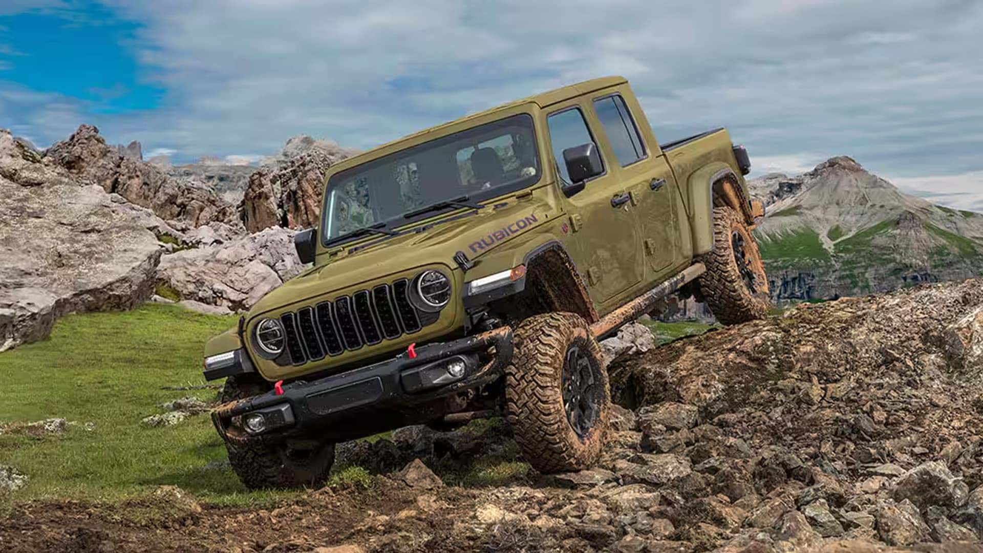 2026 Jeep Gladiator Rubicon climbing over rocks, showing high ground clearance, off-road tires, and trail-ready suspension