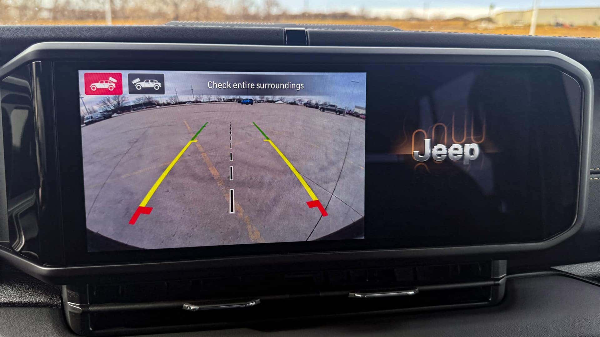 2026 Jeep Wrangler touchscreen display showing rear backup camera view with dynamic parking guidelines