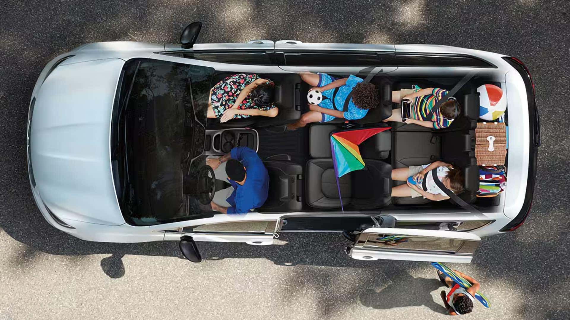 Overhead view of a family inside the 2026 Chrysler Pacifica with three-row seating, sliding door open, and spacious interior for passengers and cargo