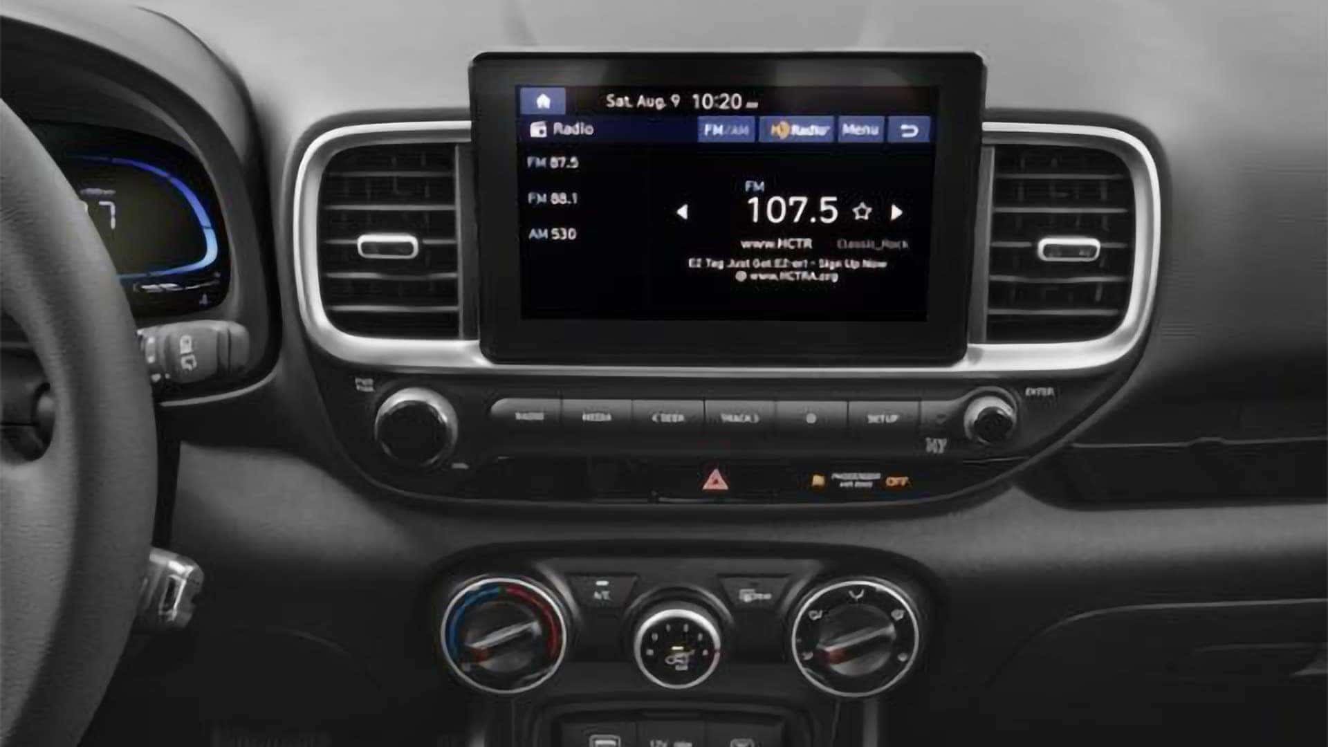 Center touchscreen infotainment display in the 2026 Hyundai Venue interior with radio interface and physical shortcut buttons below.
