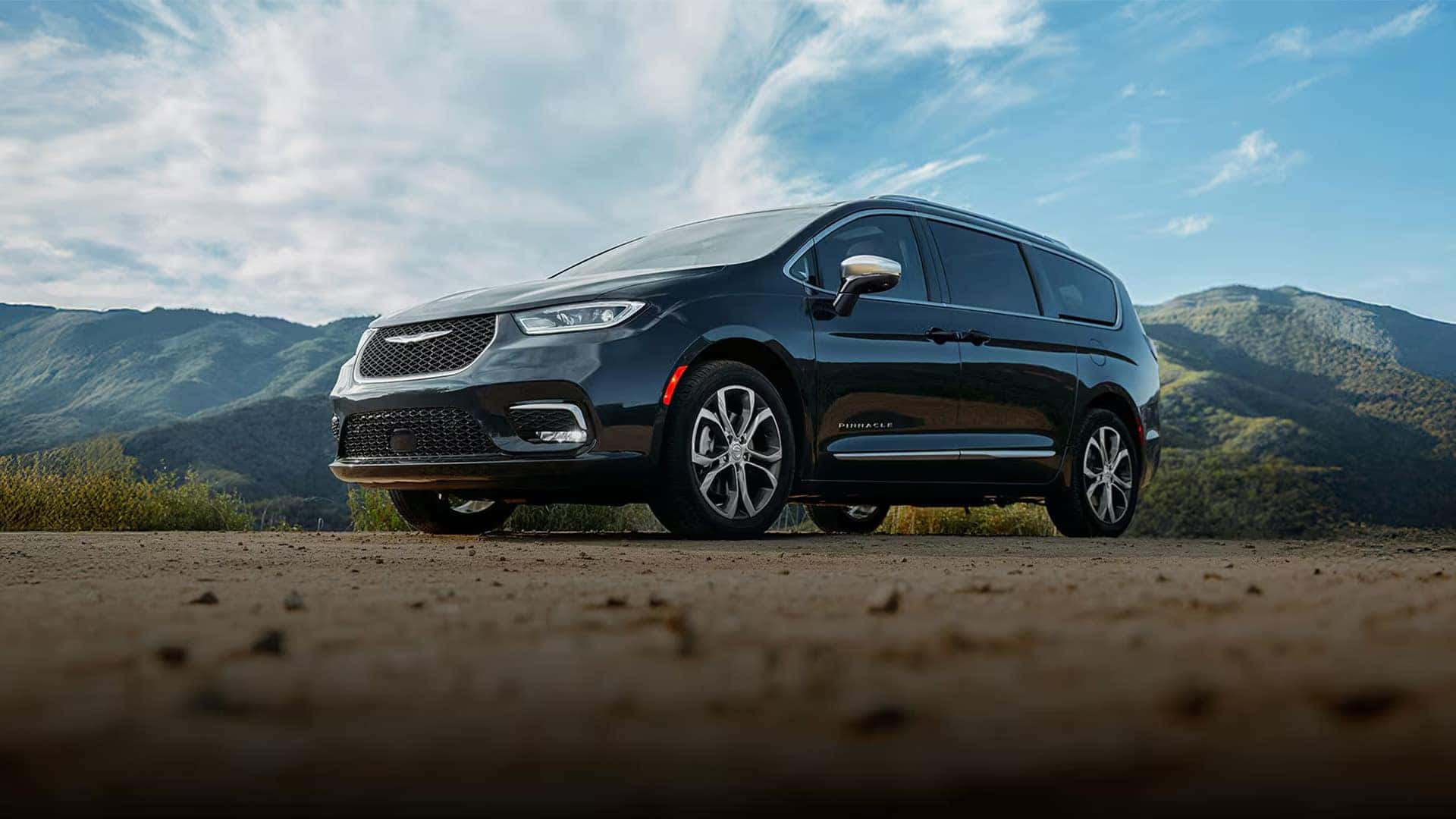 Black 2026 Chrysler Pacifica Pinnacle parked on scenic overlook highlighting premium exterior trim styling