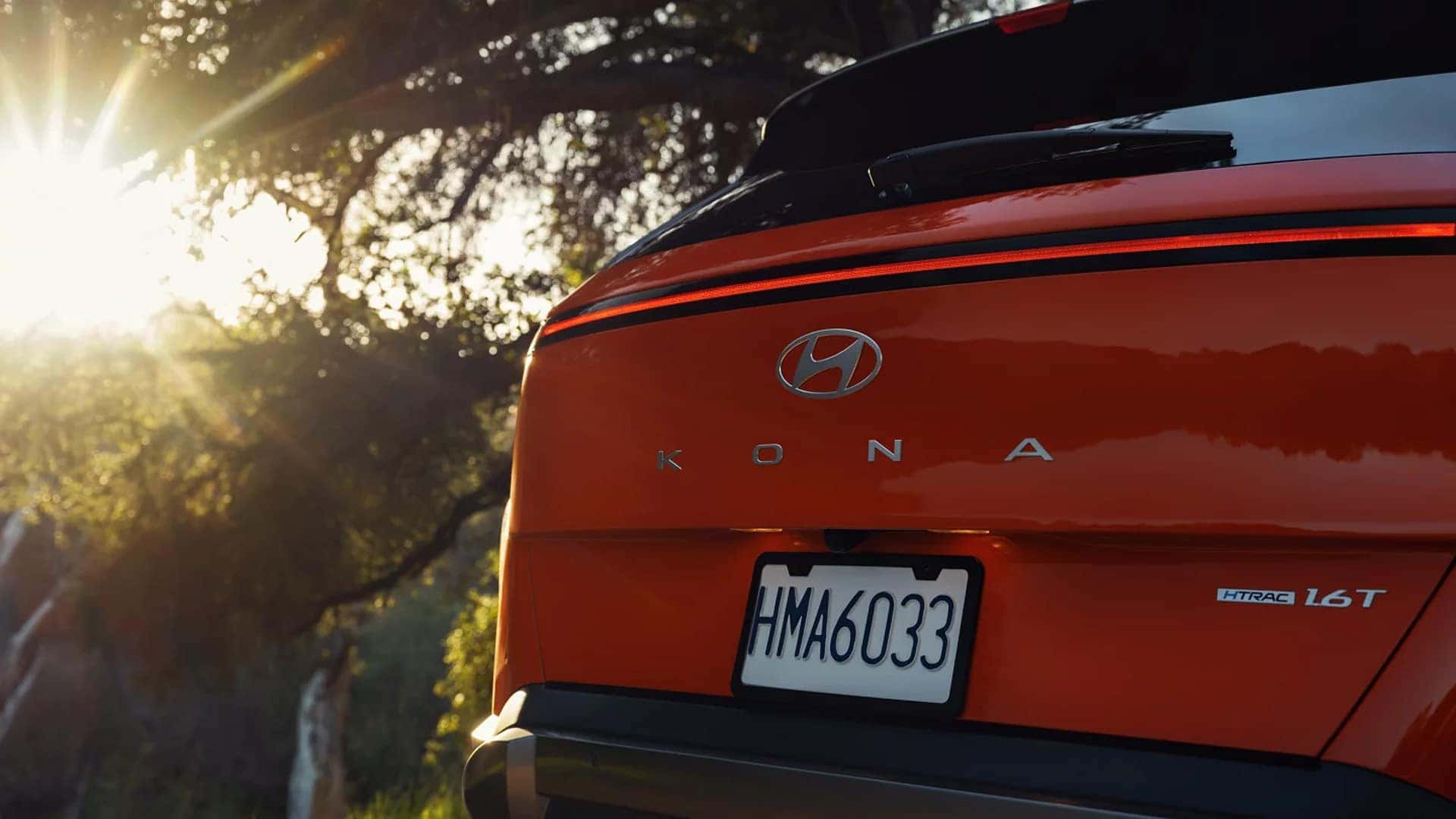 Rear view of a red 2026 Hyundai Kona showing full width LED taillight bar, Kona badging, and rear trim details.