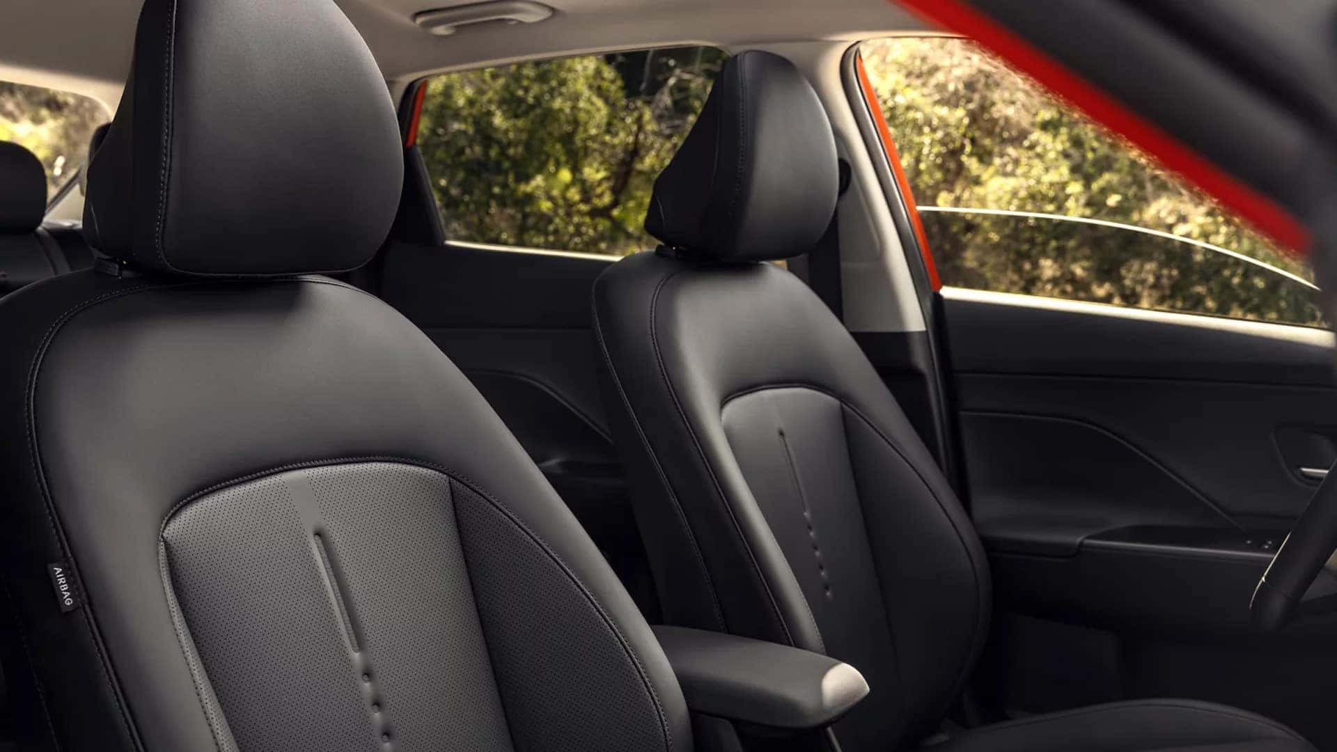 Front passenger area of the 2026 Hyundai Kona interior showing seat upholstery, door panel design, and cabin materials