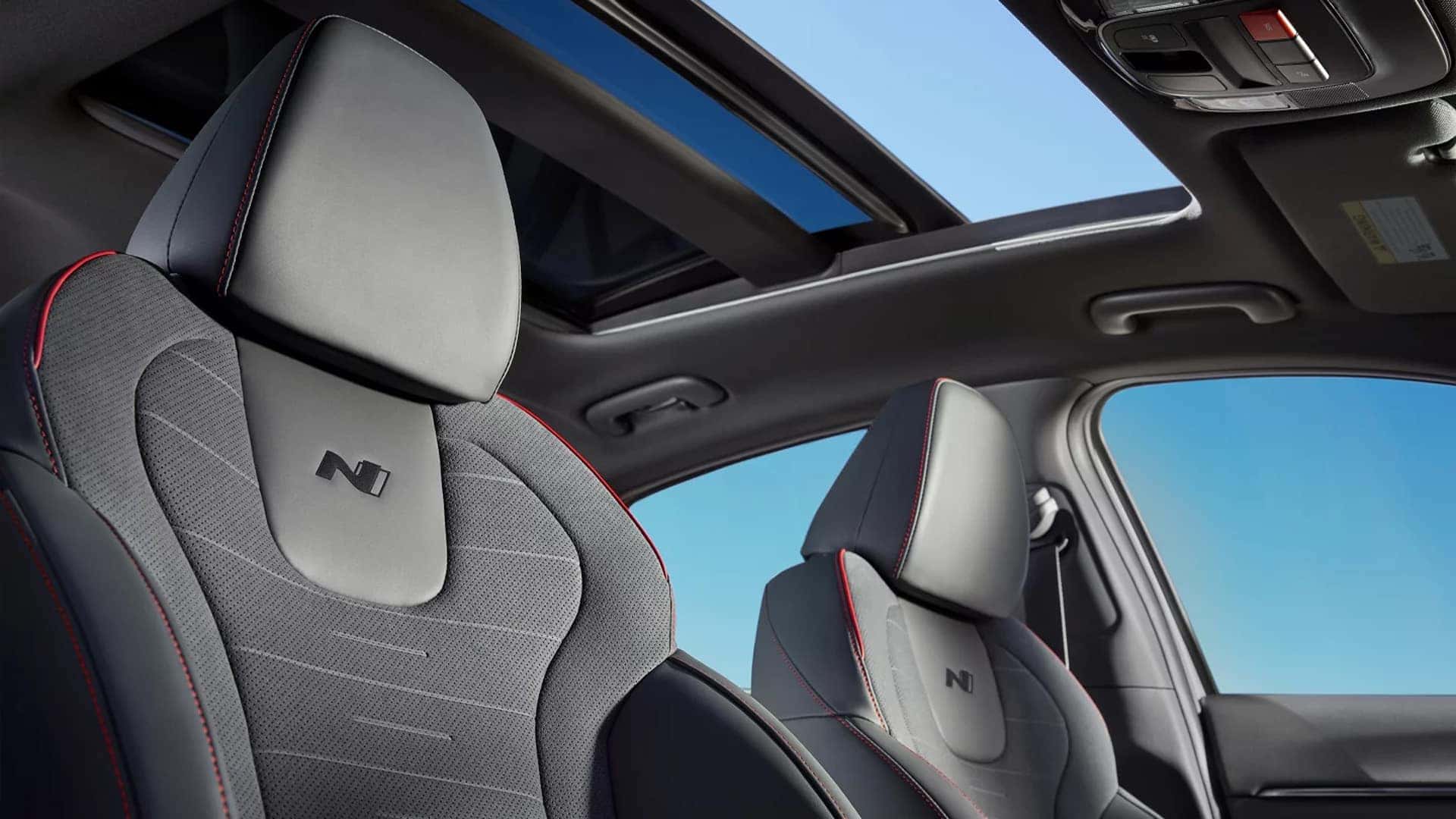 Front sport seats in the 2026 Hyundai Sonata with perforated upholstery, N logo embossing, and contrast red stitching.