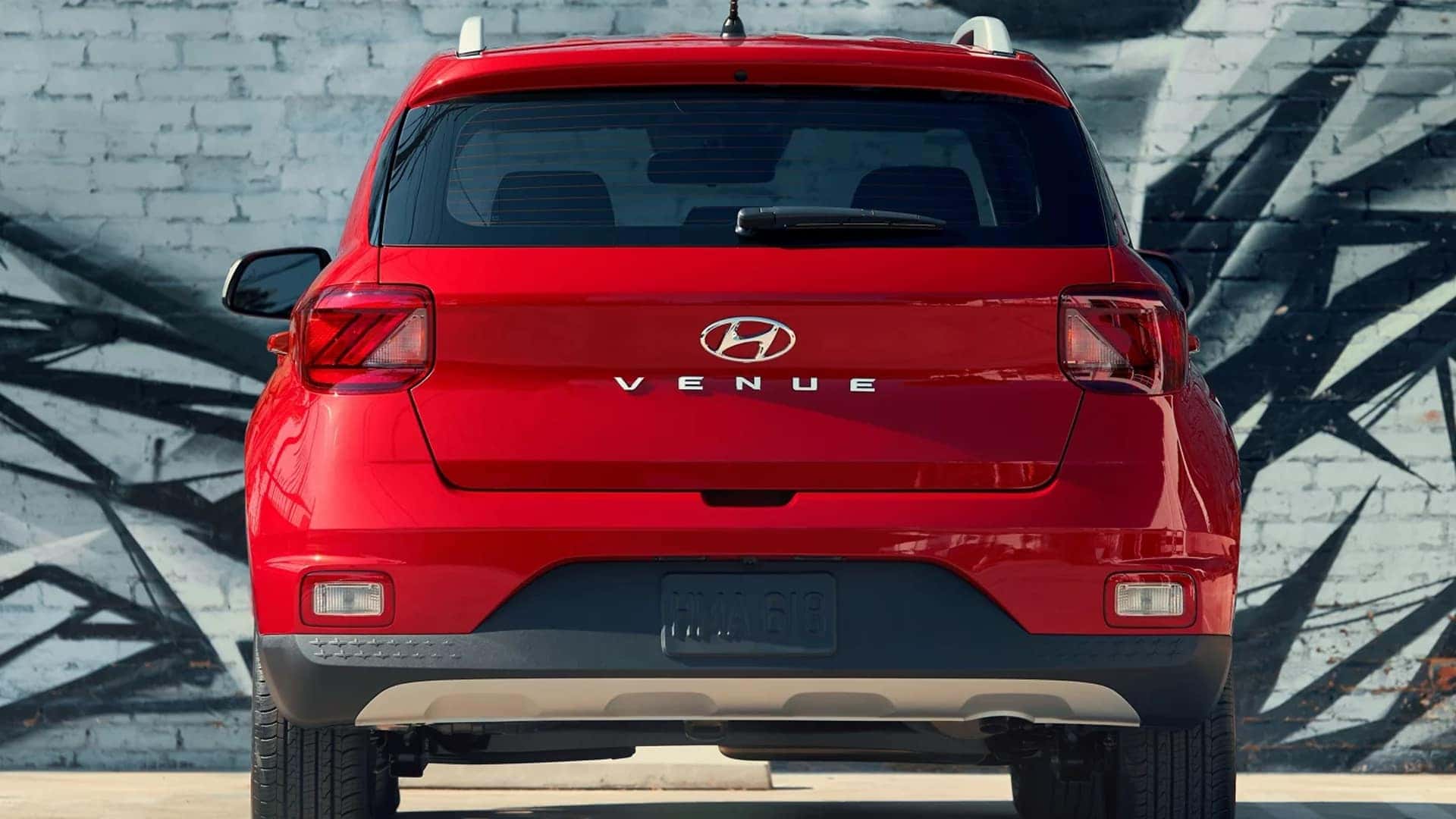 Rear view of a red 2026 Hyundai Venue showing tailgate design, Venue badging, and rear lighting details