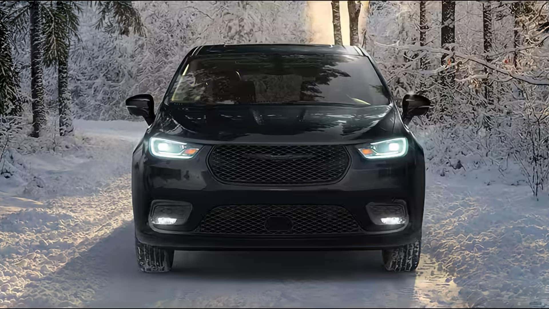 2026 Chrysler Pacifica front view driving on a snowy road, showing LED headlights and winter traction confidence