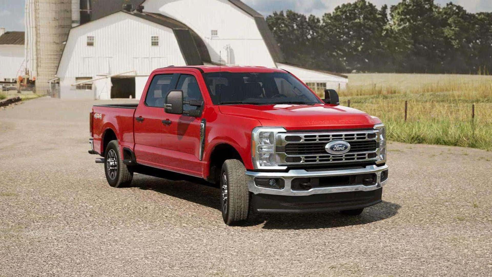 Red 2026 Ford F-250 Super Duty towing work van near rock wall, highlighting trim styling, grille design, and heavy duty towing presence.