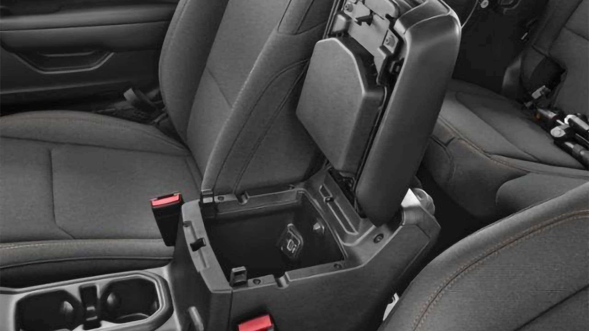 Lockable center console storage compartment inside the 2026 Jeep Wrangler interior with front seats and cupholders visible