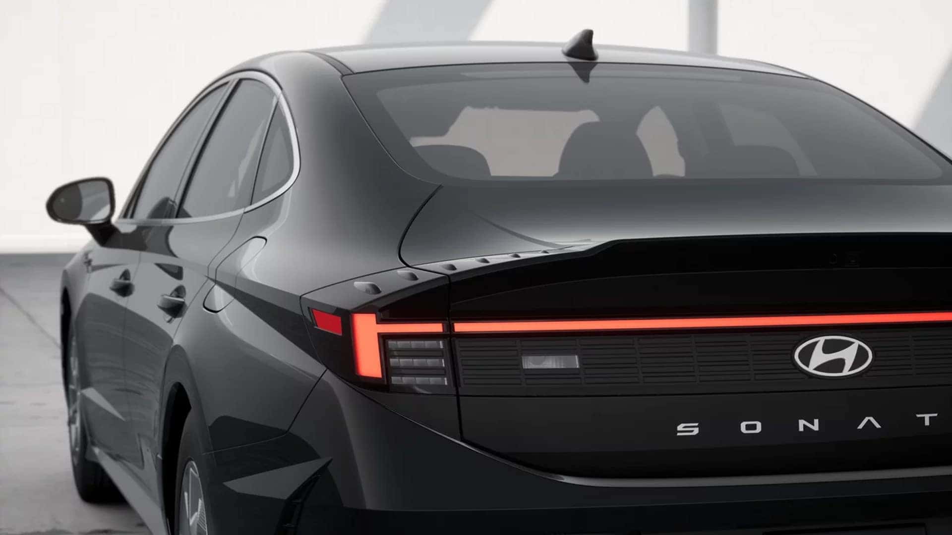 Rear three quarter view of a 2026 Hyundai Sonata showing full width LED taillight design, sculpted rear styling, and trim specific details