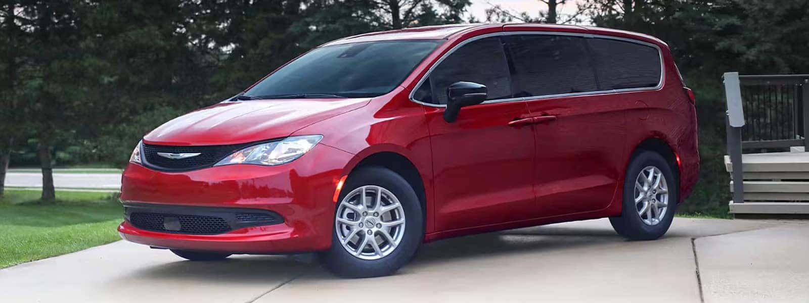 Red 2026 Chrysler Voyager parked on a driveway, front three quarter exterior view showing grille, headlights, and body lines