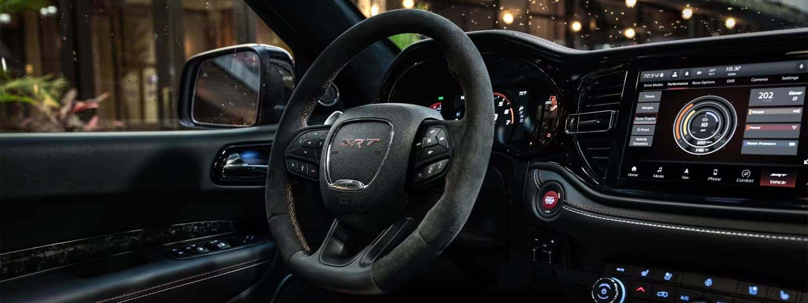 2026 Dodge Durango SRT interior cockpit with performance steering wheel, digital gauges, and Uconnect touchscreen technology display