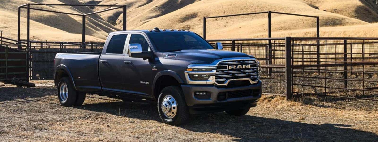 Gray 2026 RAM 3500 heavy duty pickup truck parked at a ranch with crew cab and long bed