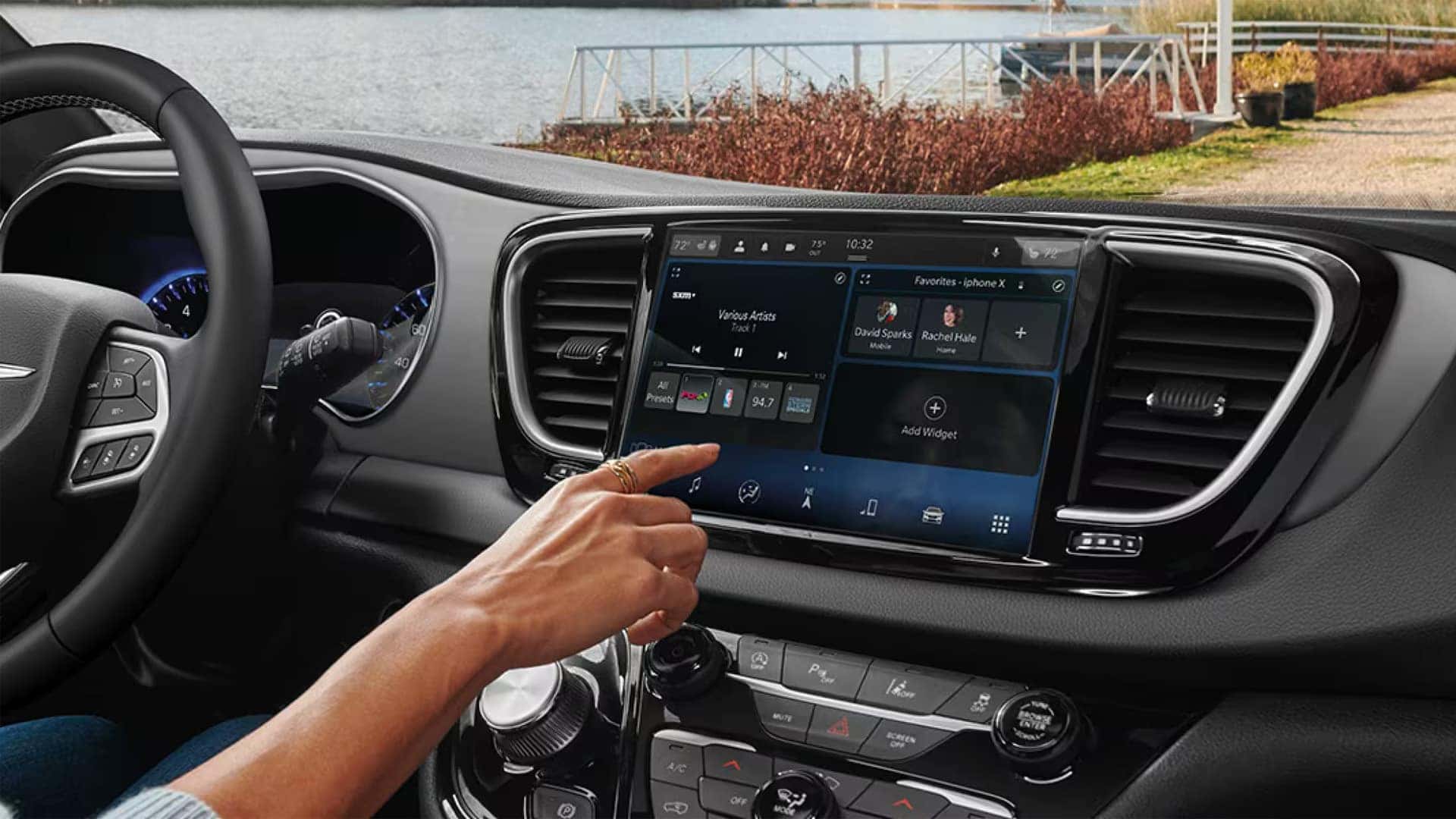 Driver using the 2026 Chrysler Voyager Uconnect touchscreen with large infotainment display in the center stack