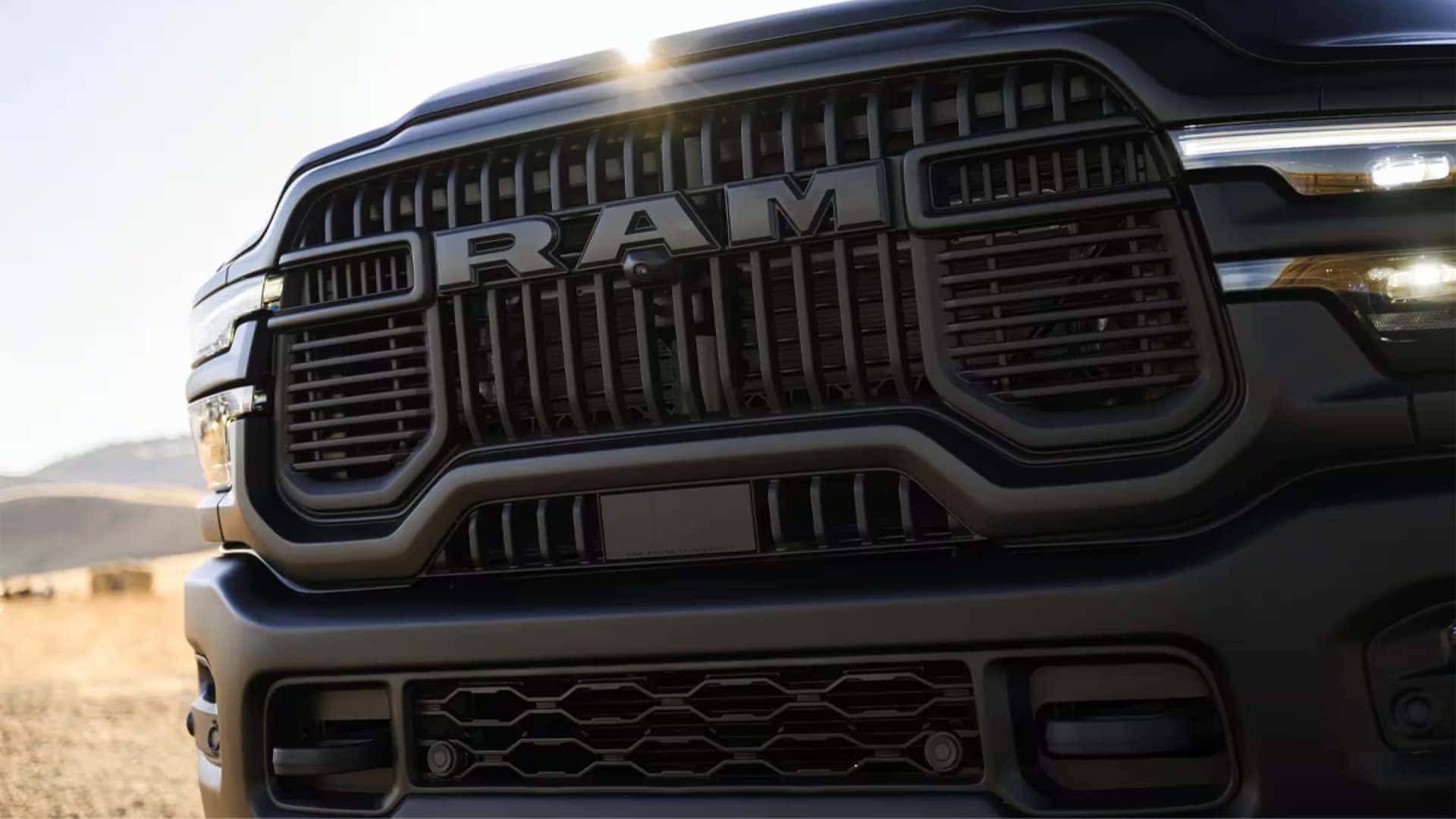 Close up of the 2026 RAM 2500 front grille with bold RAM lettering and black heavy duty grille design