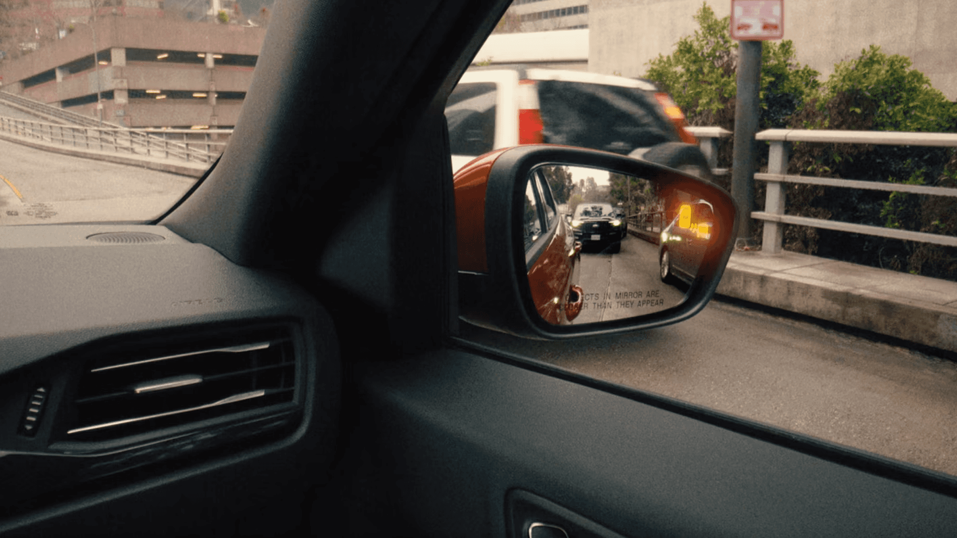 2026 Ford Escape side mirror shows blind spot warning light with vehicle approaching in adjacent lane