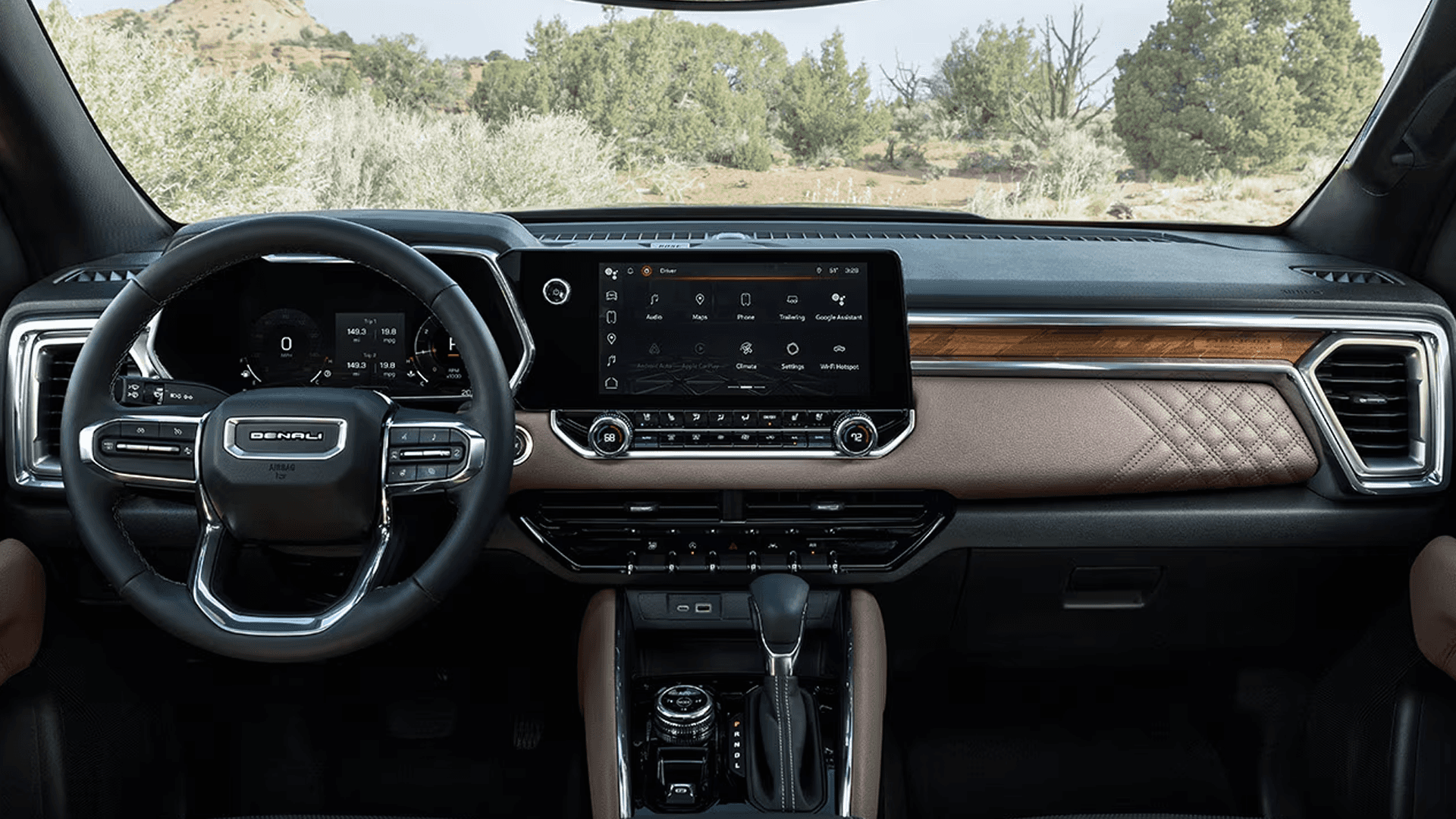 Wide view of GMC Canyon Denali interior with brown stitched dash, center touchscreen, and steering wheel