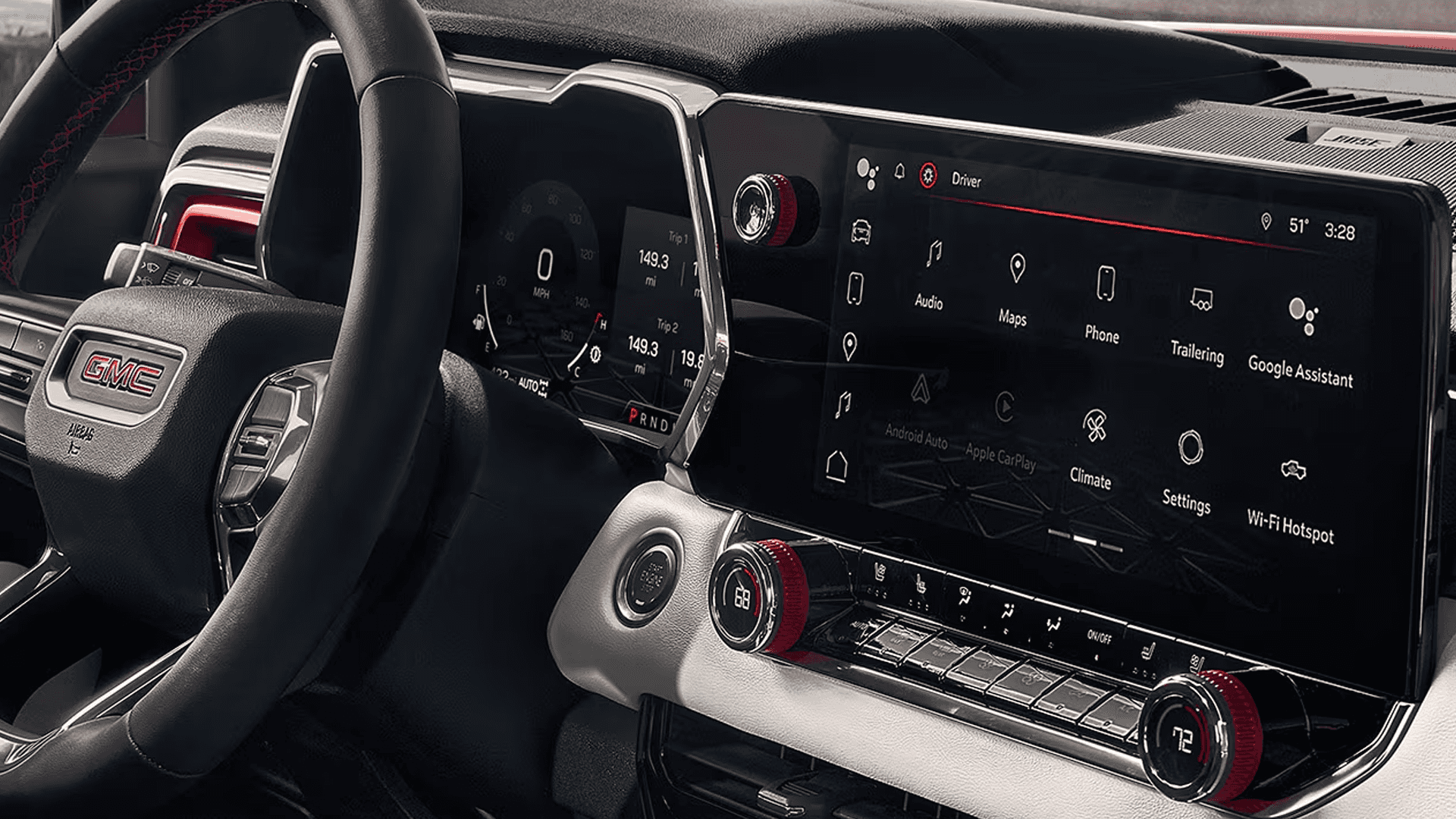 Close up of GMC Canyon cockpit showing touchscreen menu, red trim knobs, and digital gauge cluster