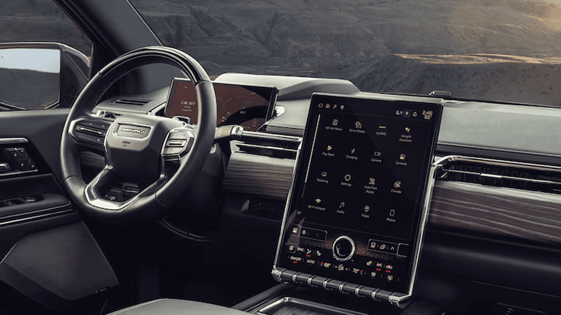 Interior view of GMC dashboard with steering wheel, digital gauge display, and large vertical touchscreen
