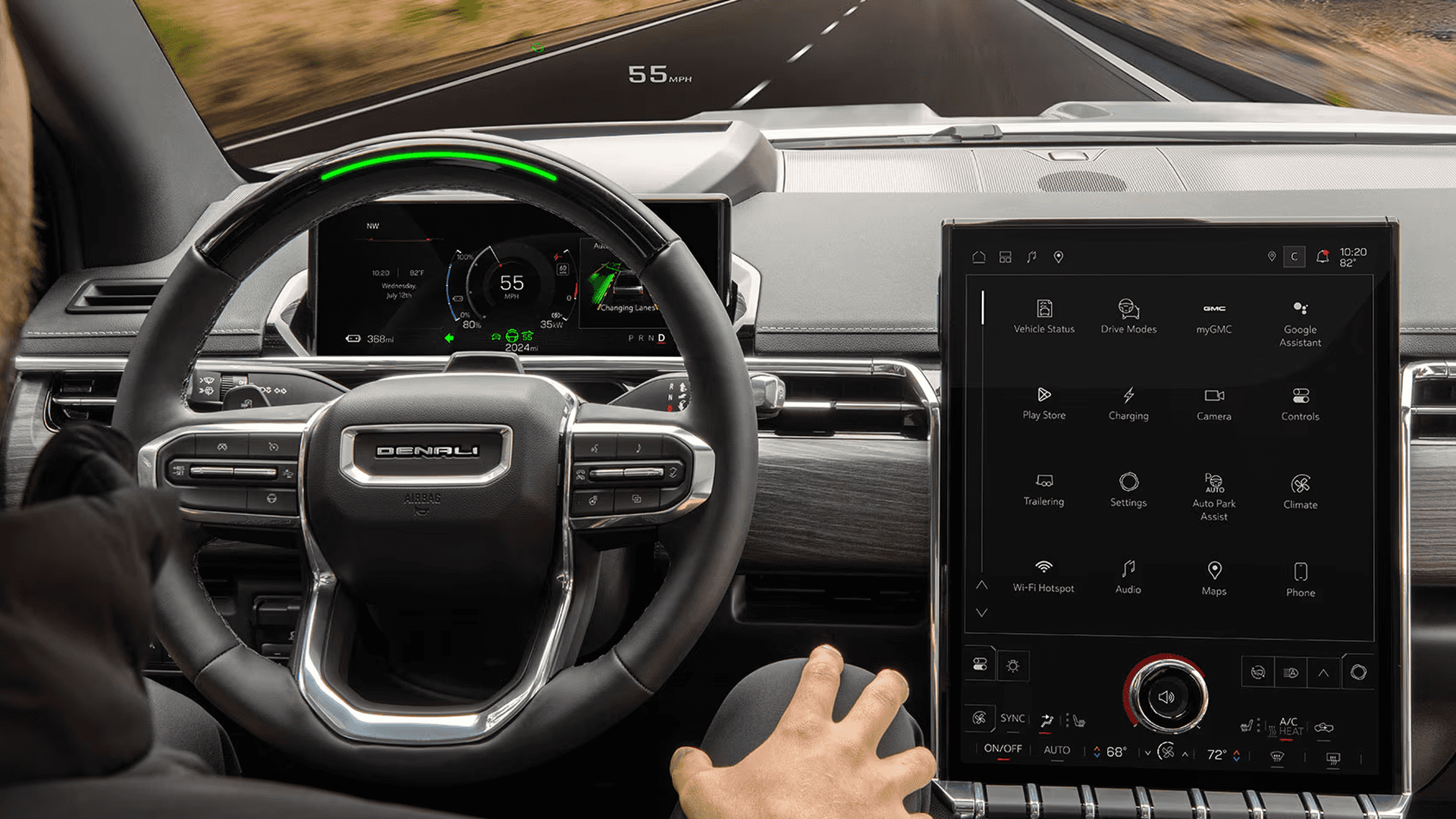 Driver view of GMC Sierra EV interior with steering wheel, digital display, and large touchscreen
