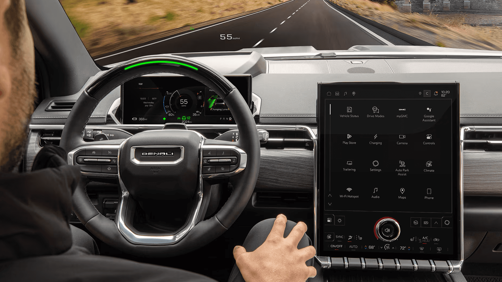 Driver view with steering wheel, digital screens, head-up display, and road visible through windshield