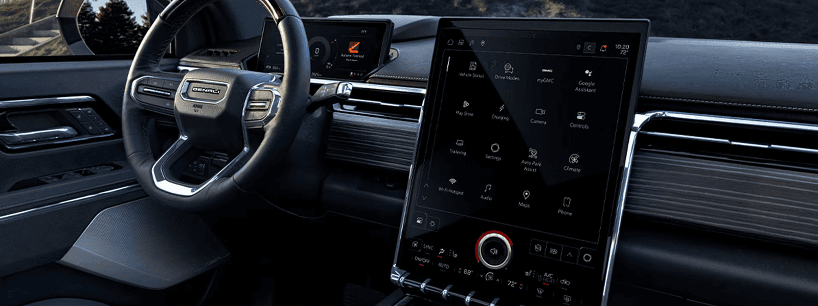 GMC Sierra EV interior at dusk with steering wheel, driver display, and large vertical touchscreen illuminated